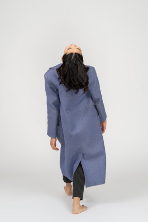 Woman in coat throwing head back