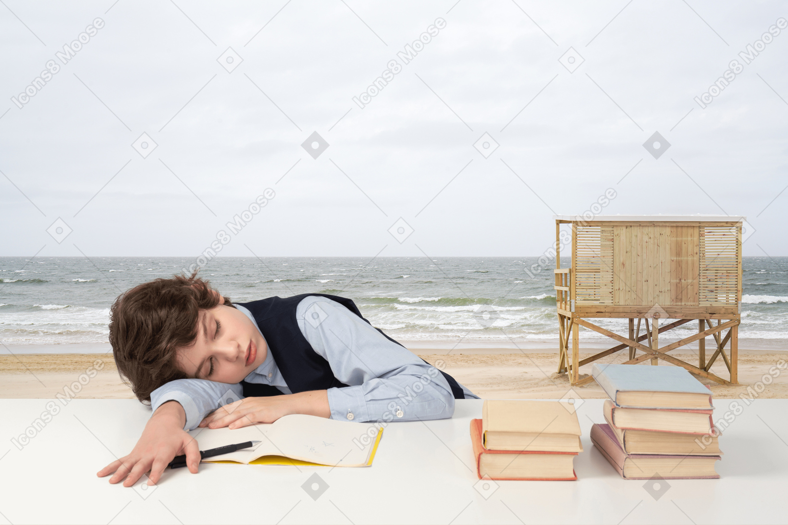 A boy sleeping on a beach with books on a table