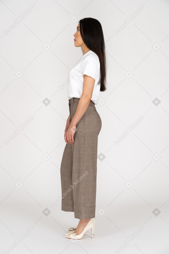 一个年轻的女人，在马裤站着不动时仰望的侧视图
