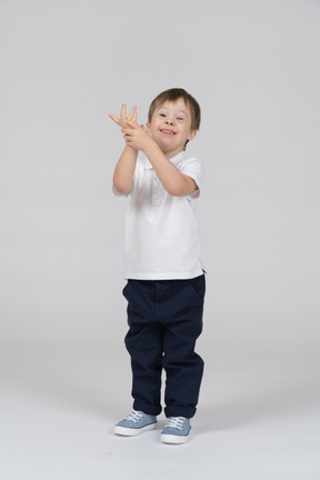 Cheerful little boy holding his hand up