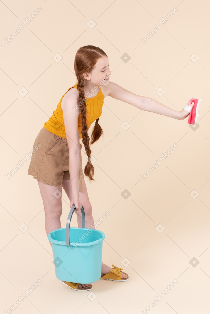 Teenage girl holding bucket and washcloth