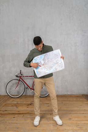 Front view of a man looking and pointing at a map