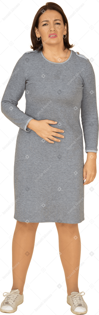 복통으로 고통받는 회색 드레스를 입은 여성의 전면 모습