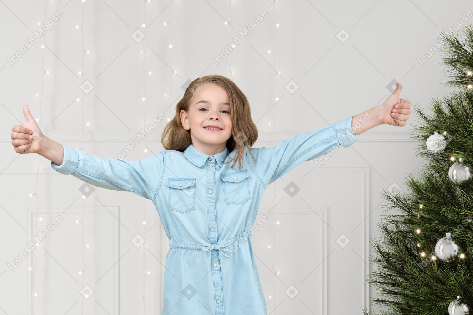 A little girl standing in front of a christmas tree