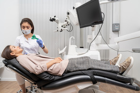 Comprimento total de uma dentista fazendo um registro dentário para sua paciente em um armário de hospital