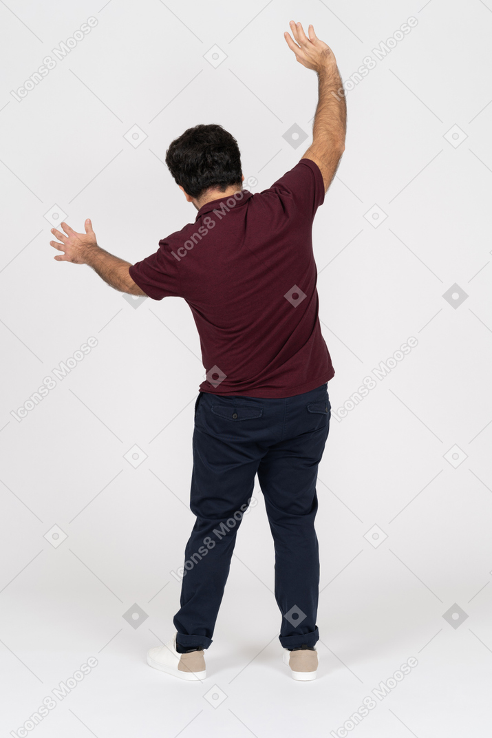Un giovane che alza le braccia con le spalle alla telecamera