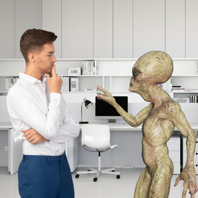 A man is talking to an alien in an office