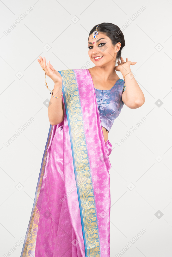 Young indian woman in purple sari touching hair