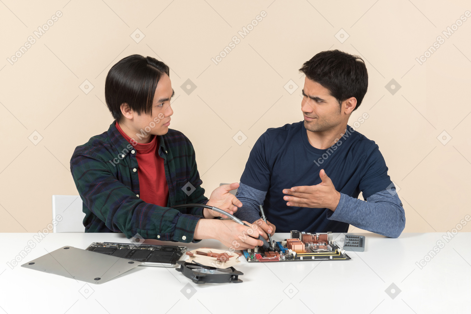 Two young geeks with some details on the table having some issues
