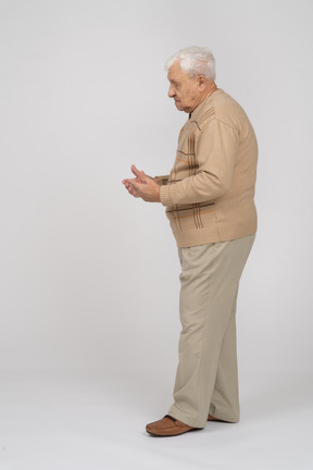 何かのサイズを示すカジュアルな服装の老人の側面図