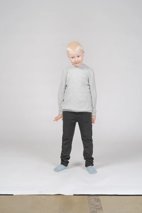 Vista frontal de un niño de pie tímidamente