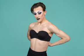 Drag queen che aggancia il reggiseno nero nella parte posteriore