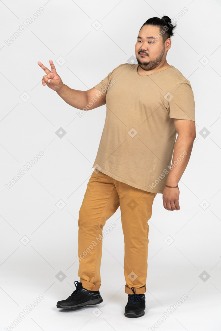 Plump asian man showing number two with his fingers
