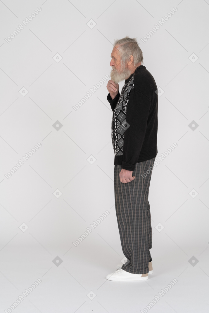 Side view of an old man holding his beard