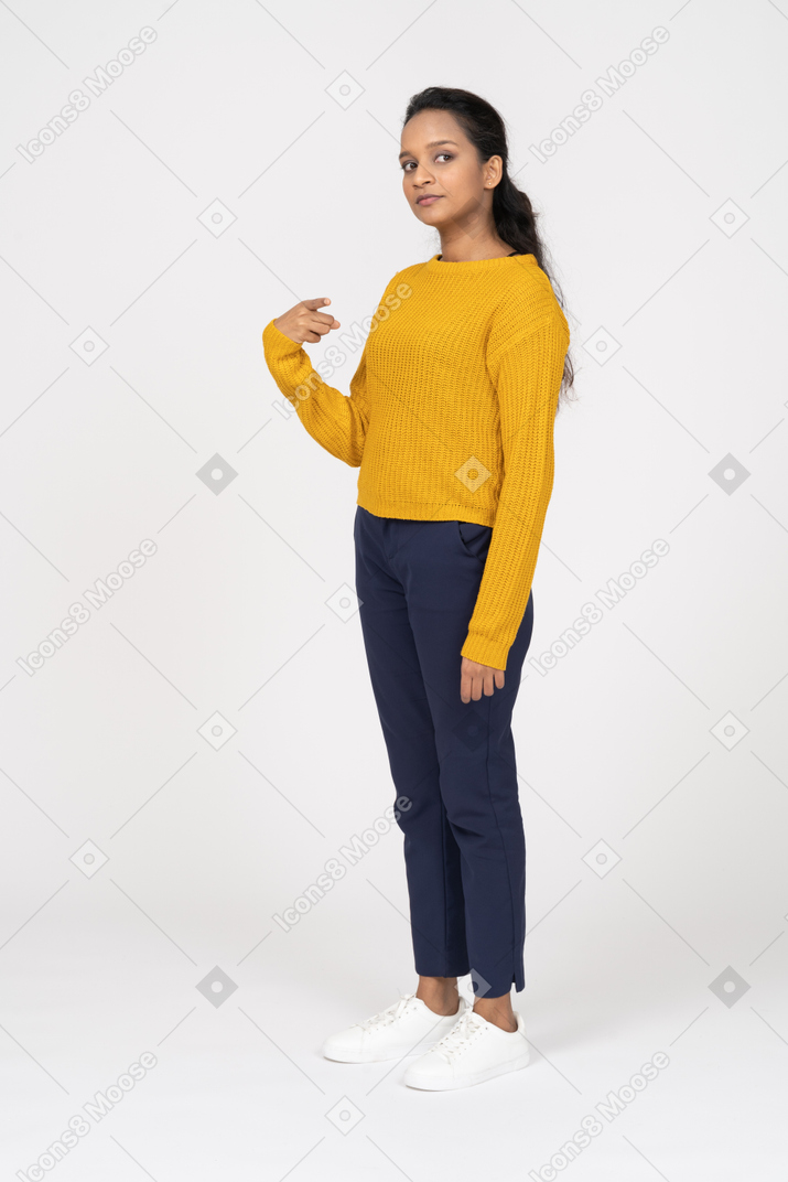 Side view of a girl in casual clothes standing with raised hand