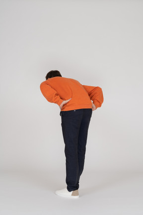 Jeune homme en sweat-shirt orange posant