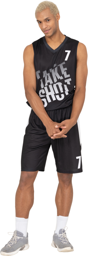 Front view of a shy young male basketball player holding hands together