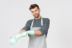 Jeune femme au foyer mettant des gants