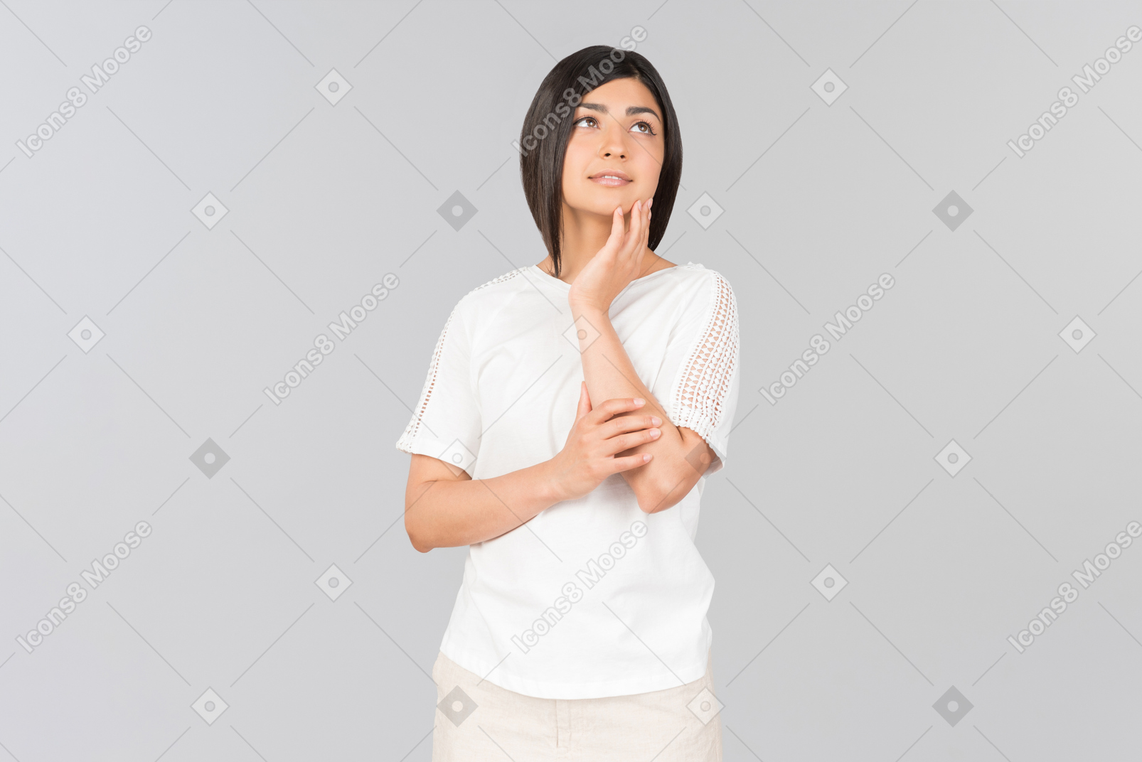 Rêveuse jeune femme indienne debout avec ses mains croisées