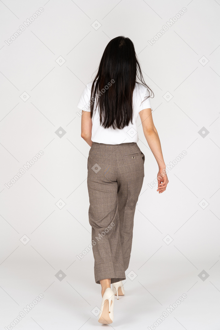 Back view of a walking young lady in breeches and t-shirt