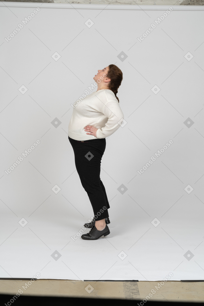 Side view of a plump woman in casual clothes looking up