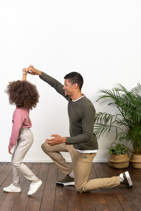 Young man on a knee with his daughter