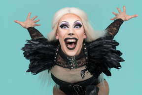Drag queen evil laugh loaning forward and looking at camera