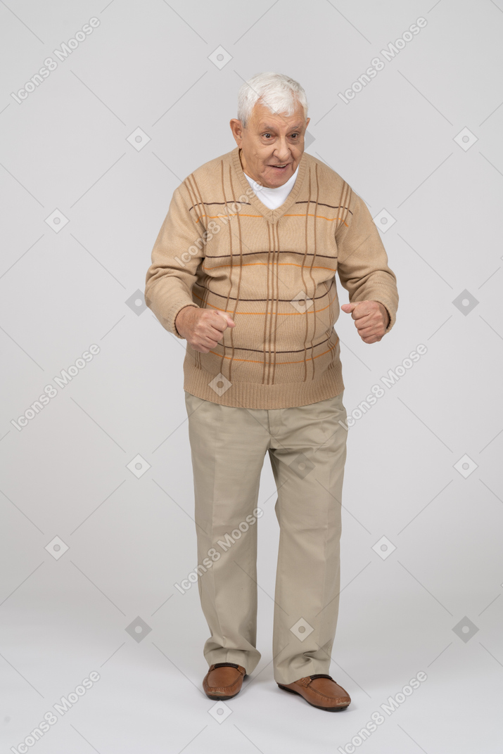 Vista frontale di un vecchio felice in abiti casual che spiega qualcosa