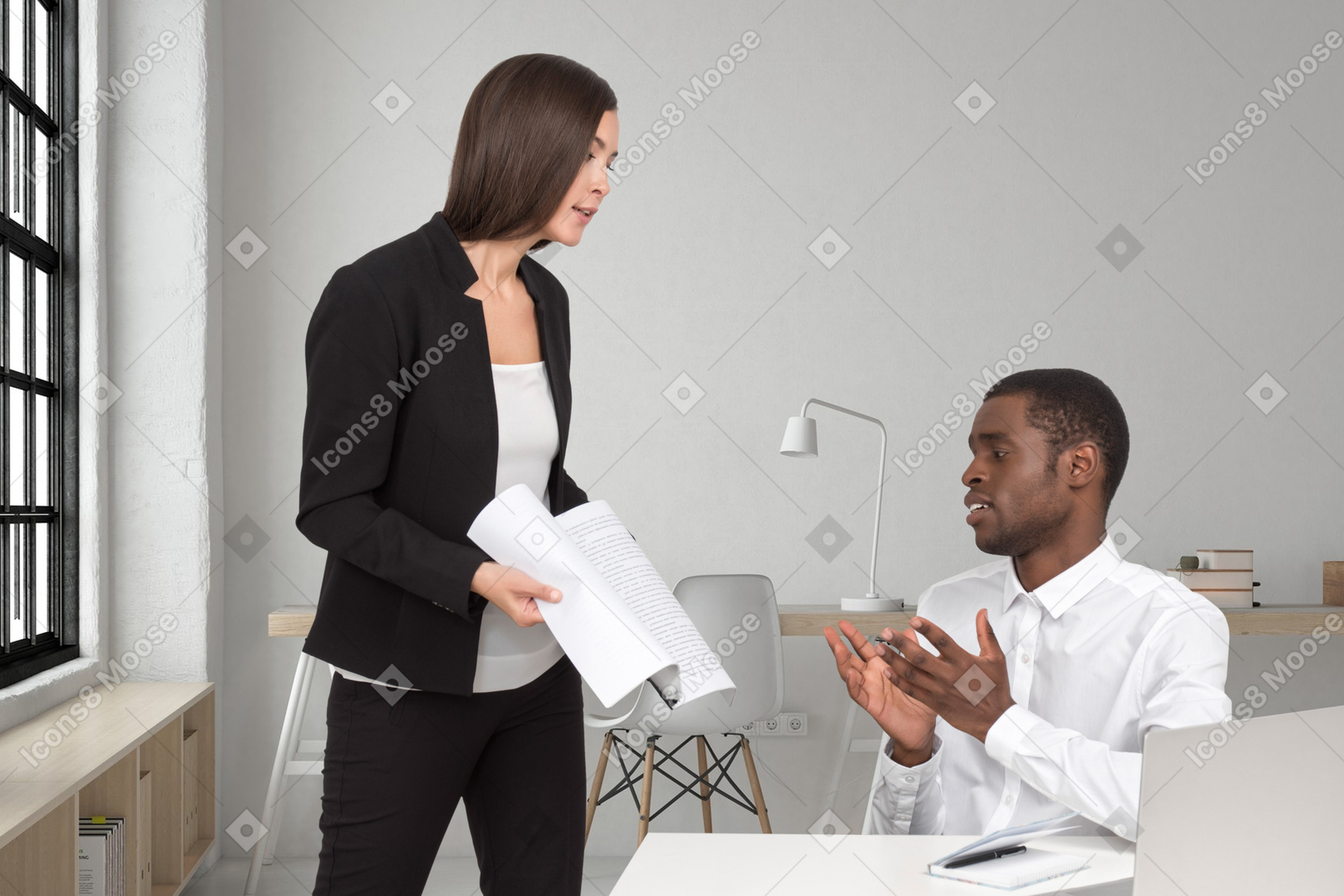 A man and woman talking at a desk