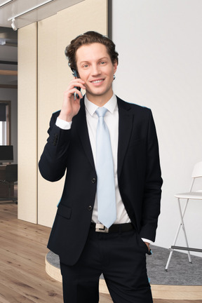 A man in a suit talking on a cell phone