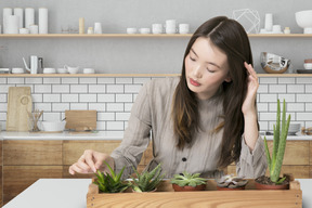 A woman sitting at a table with succulents in front of her