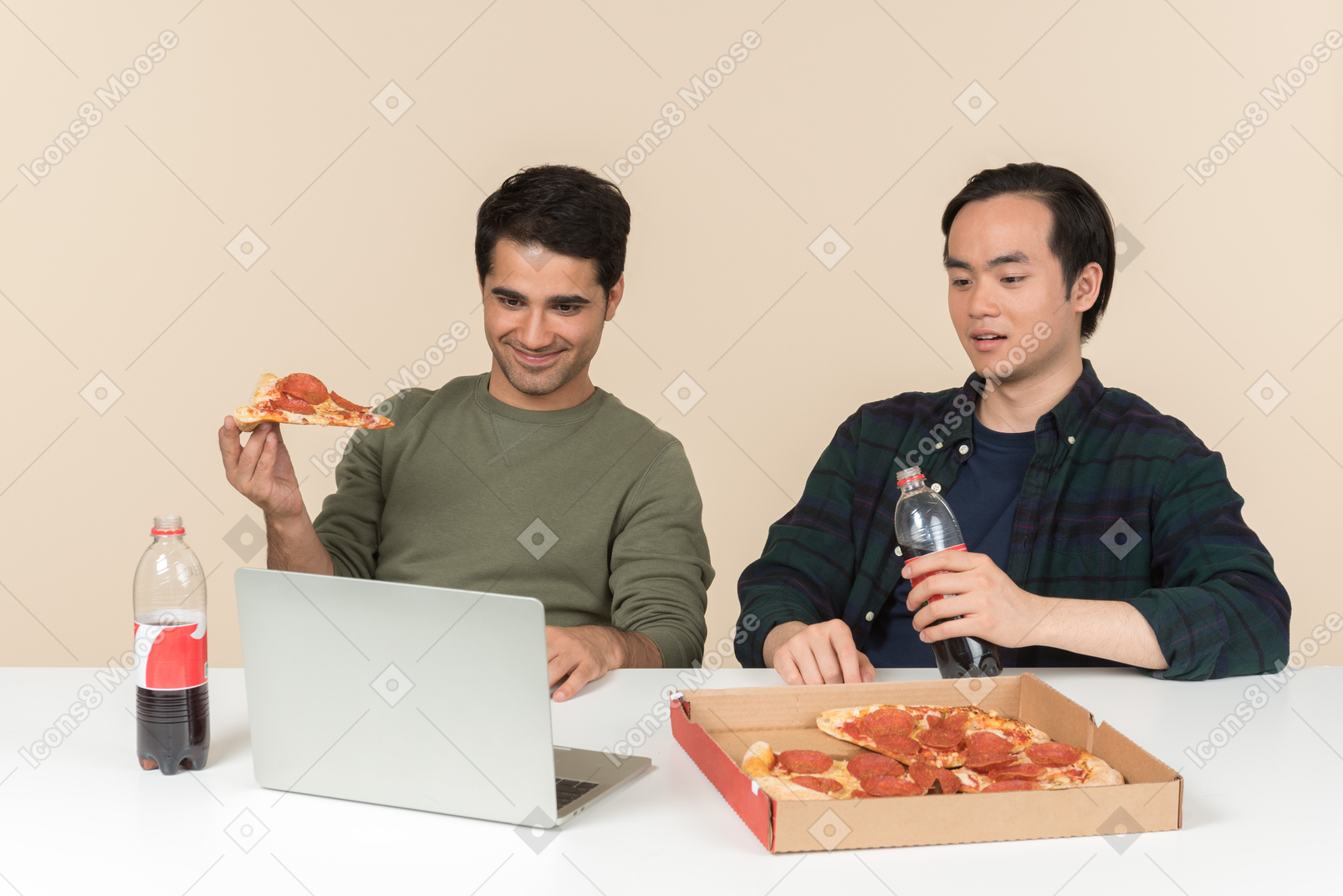 不同肤色的朋友吃垃圾食品和看电影在笔记本电脑上