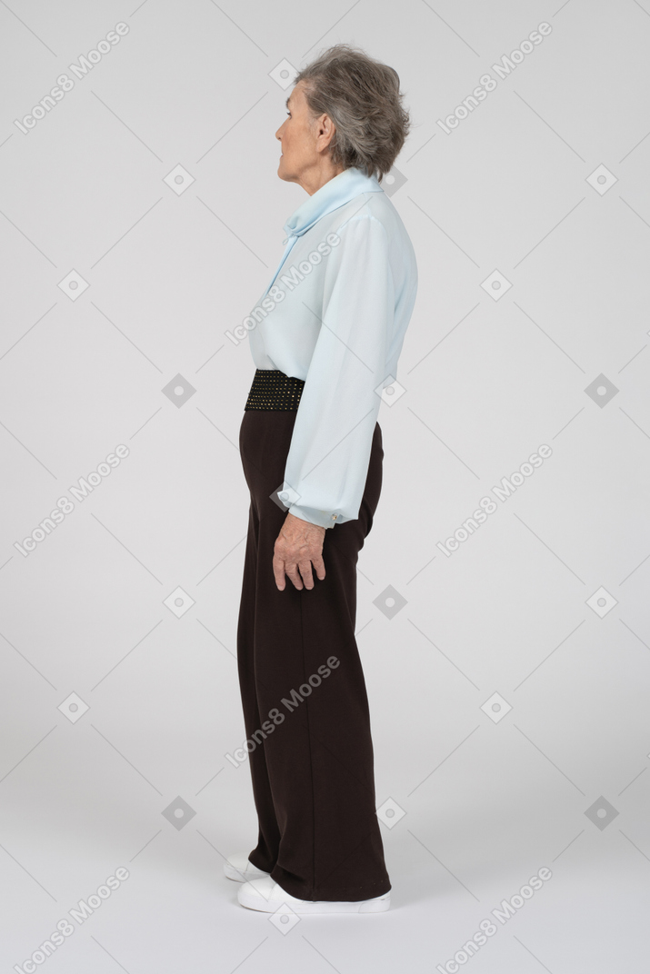 Side view of old woman standing and turning away
