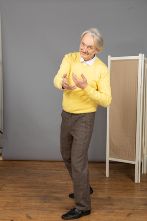 Vista di tre quarti di un uomo anziano attraente che tende le mani
