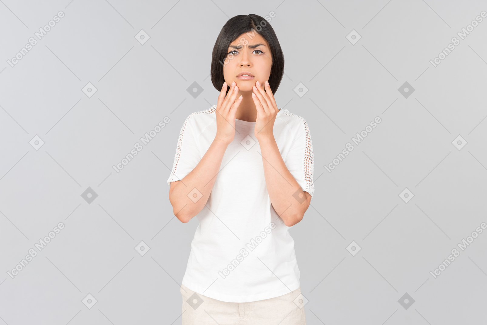 Preoccupied looking young indian woman touching her face