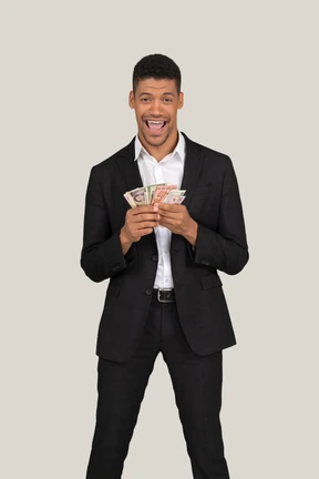 Three-quarter view of a young man in black suit holding banknotes