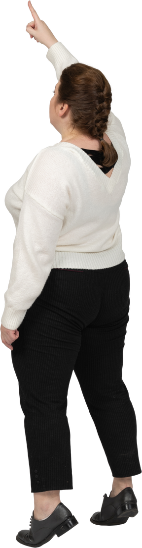 Vista posteriore di una donna plus size in abiti casual in piedi con il braccio alzato