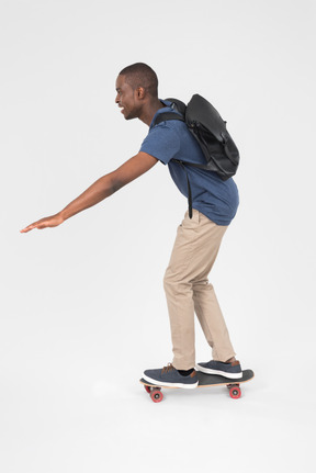 Male tourist standing half sideways back to camera on skateboard