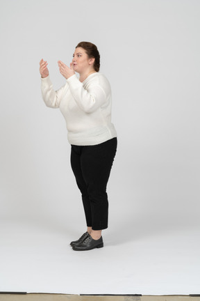 Side view of an impressed plump woman in casual clothes gesturing