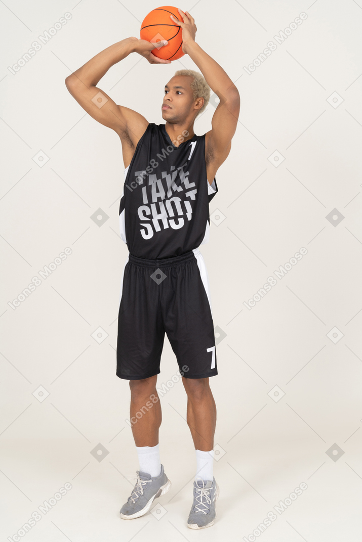 Vista frontal de um jovem jogador de basquete jogando uma bola