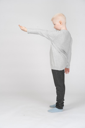 Side view of a boy holding out his hand