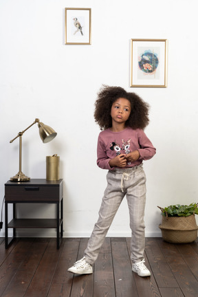 Cute girl kid posing on the apartments background