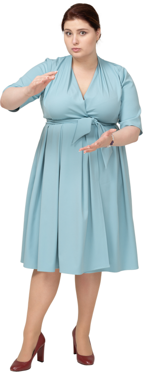一个穿着蓝色连衣裙的女人的前视图，显示某物的大小