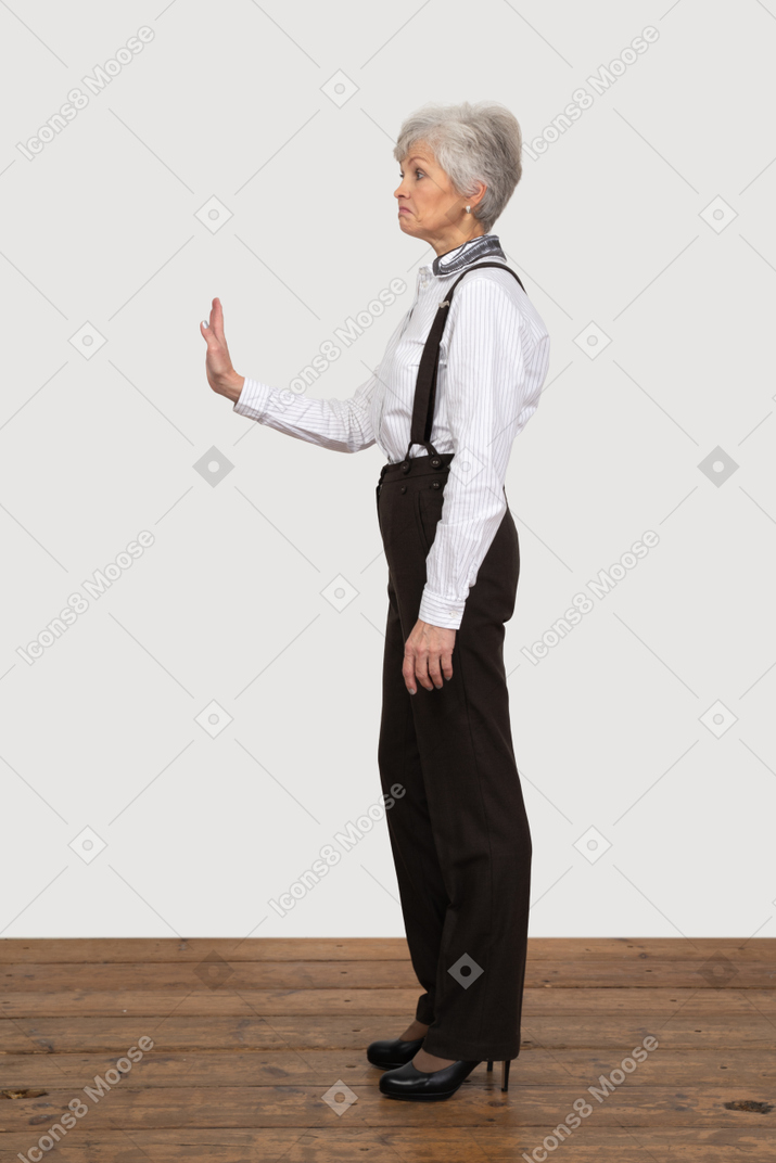 Vista lateral de una anciana negándose en ropa de oficina