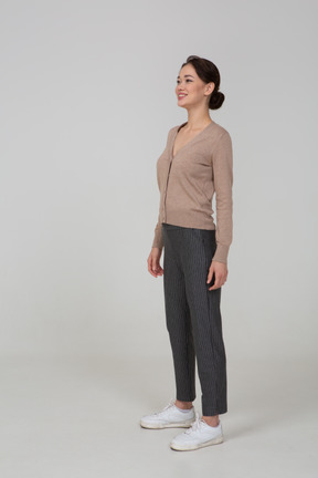 Vista de tres cuartos de una mujer sonriente en jersey y pantalones