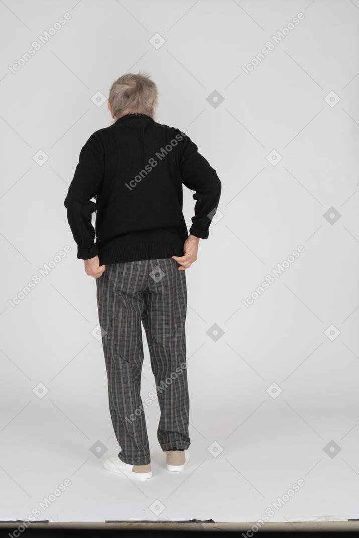 一位老人调整毛衣的后视图