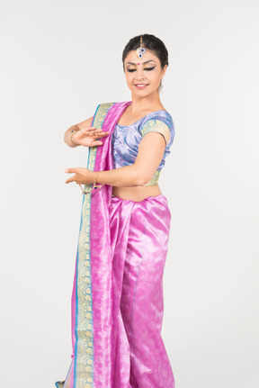 Young indian woman in purple sari dancing