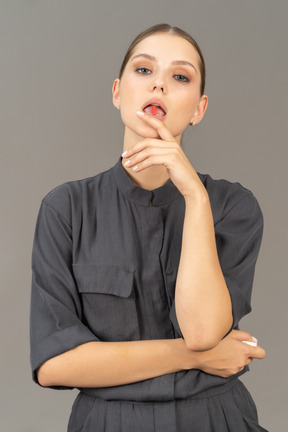 Vue de face d'une jeune femme dans une combinaison prenant la pilule