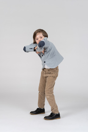 Boy holding hands at chest with elbows forward