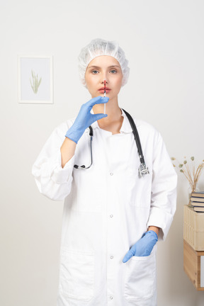 Front view of a young female doctor holding a syringe